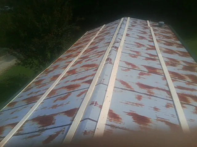 Rusted metal roof panels with new wood purlins before replacement — Storm Damage Roof Repair in Visalia by Roofing Brothers