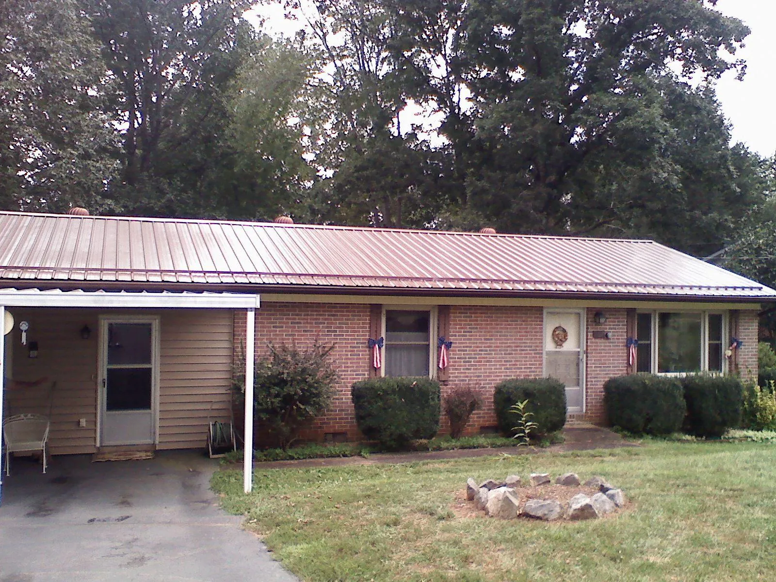 Bronze metal roof and carport on a brick ranch home — Roof Repair work by our crew in Visalia